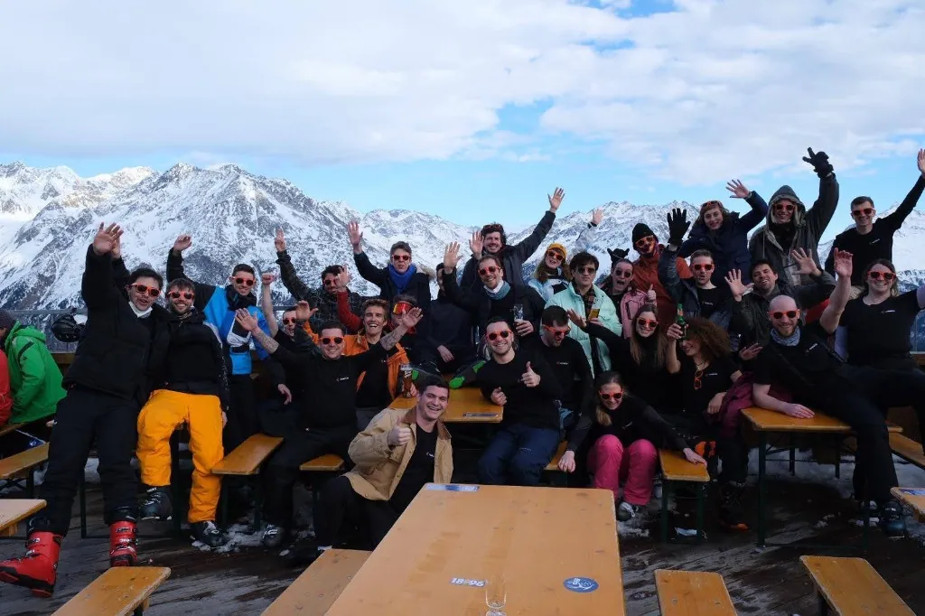 Luzmo team members cheering on a mountain terrace during a ski trip.